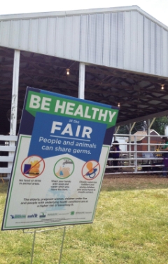 Signs inform fair-goers about the best ways to prevent the spread of zoonotic disease.