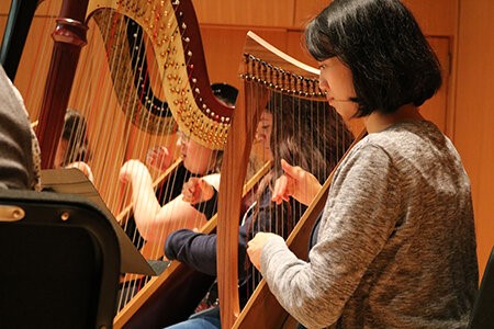 Professor Huang assists Harp Day participants during the Harp Jam rehearsal.