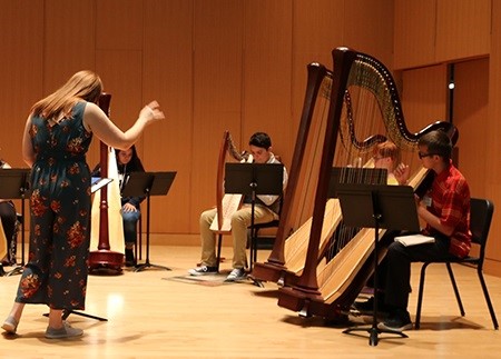 Guest artist and composer Molly O'Roark works with a group of students from Sturgis High School during Harp Day.