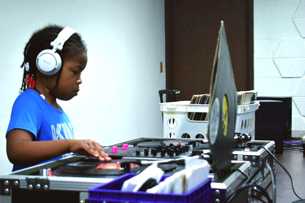 A young, emerging sound artist learns DJing and turntablism at a community event at the Pontiac Public Library.