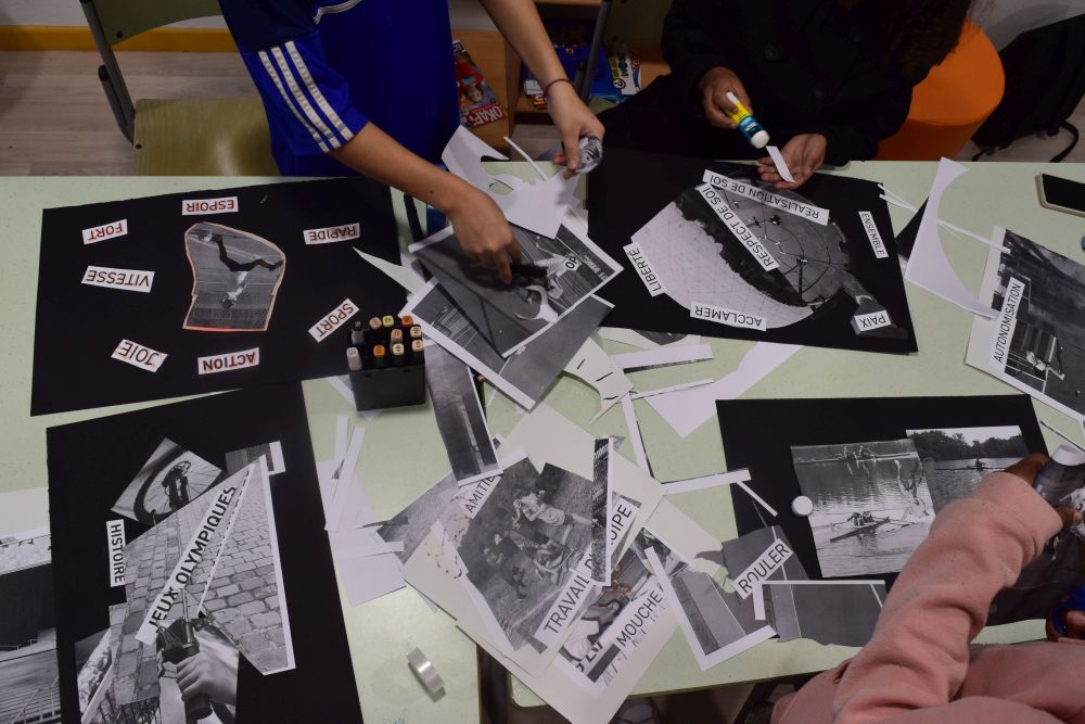 Children use scissors and glue sticks to cut out photos and words and create collages.