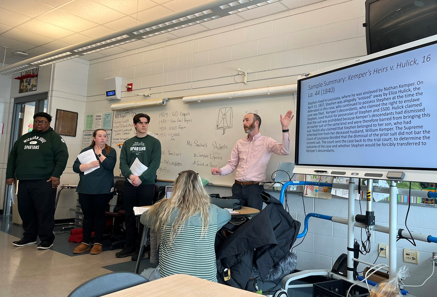 Professor Justin Simard describes a case summary as students Kenneth Ayers and Caitlin Butcher, College of Law, and Jesse Doolin, pre-law, look on.