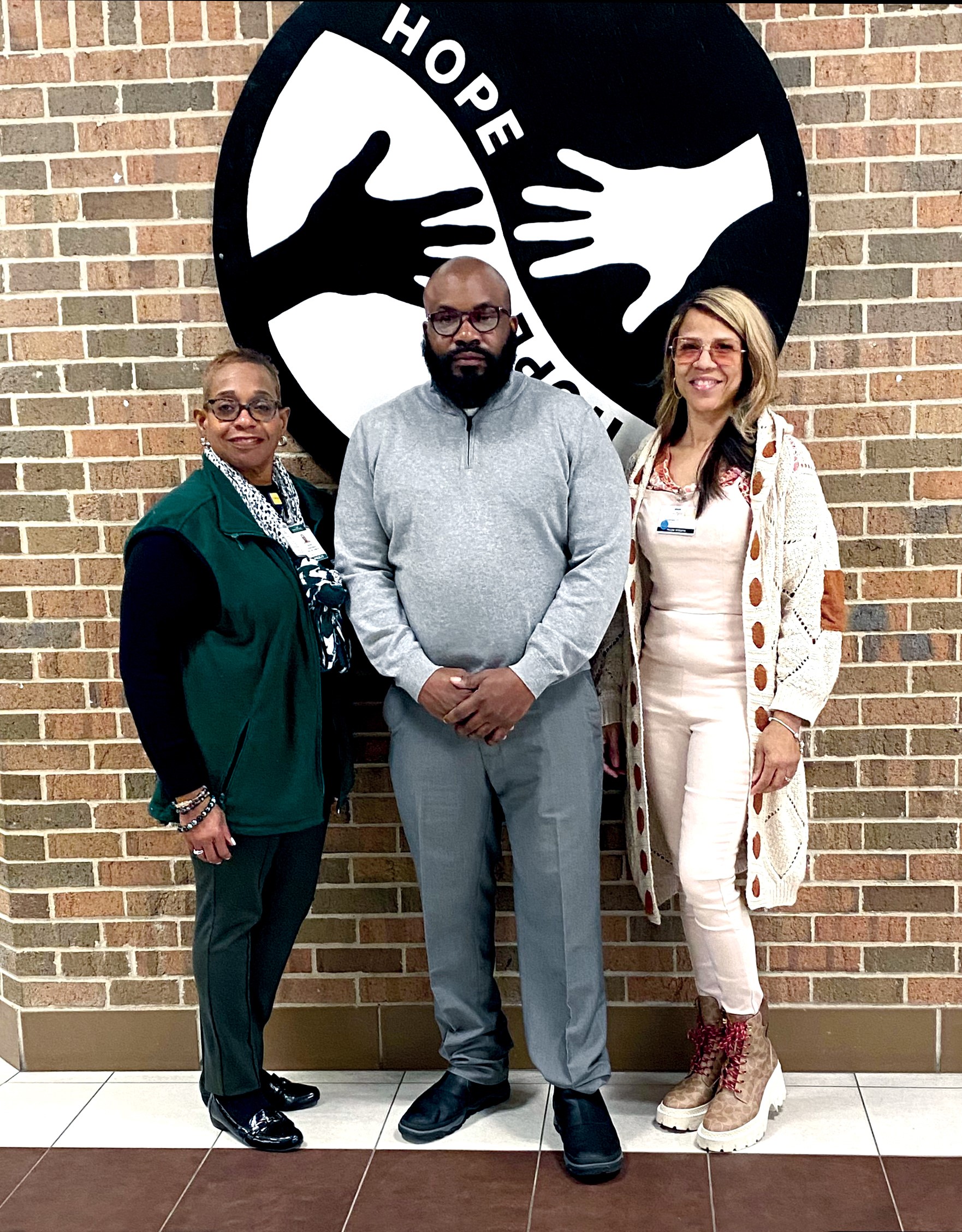 Rhonda Conner-Warren, Waymond Hayes, and Nicole Williams standing in front of a Focus: HOPE sign.