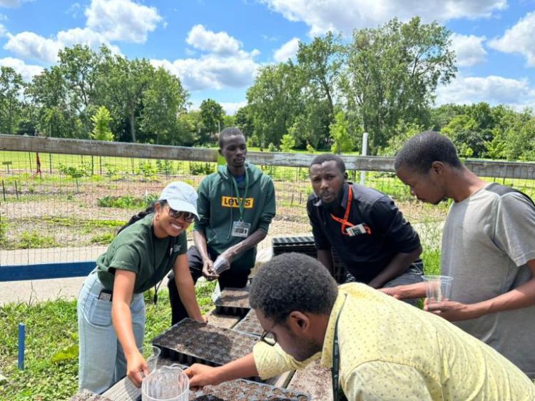 Pharis joins fellows in planting soybean seeds during their visit to the Allen Neighborhood Center.