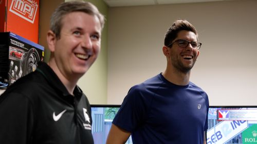 David Ferguson and Jordan Taylor stand in Ferguson’s MSU lab, smiling while discussing performance research and race car simulations.
