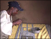 Binde Traore does bogolan fabric art at his family compound in Kolokani, Mali.