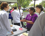 Meredith Good (center) and Laura Carravallah (right) demonstrate hand-washing techniques to Yvonne Lewis (left) of the Kidney Foundation at the September 6 health fair.