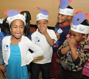 Young DAPCEP students sport molecule hats.