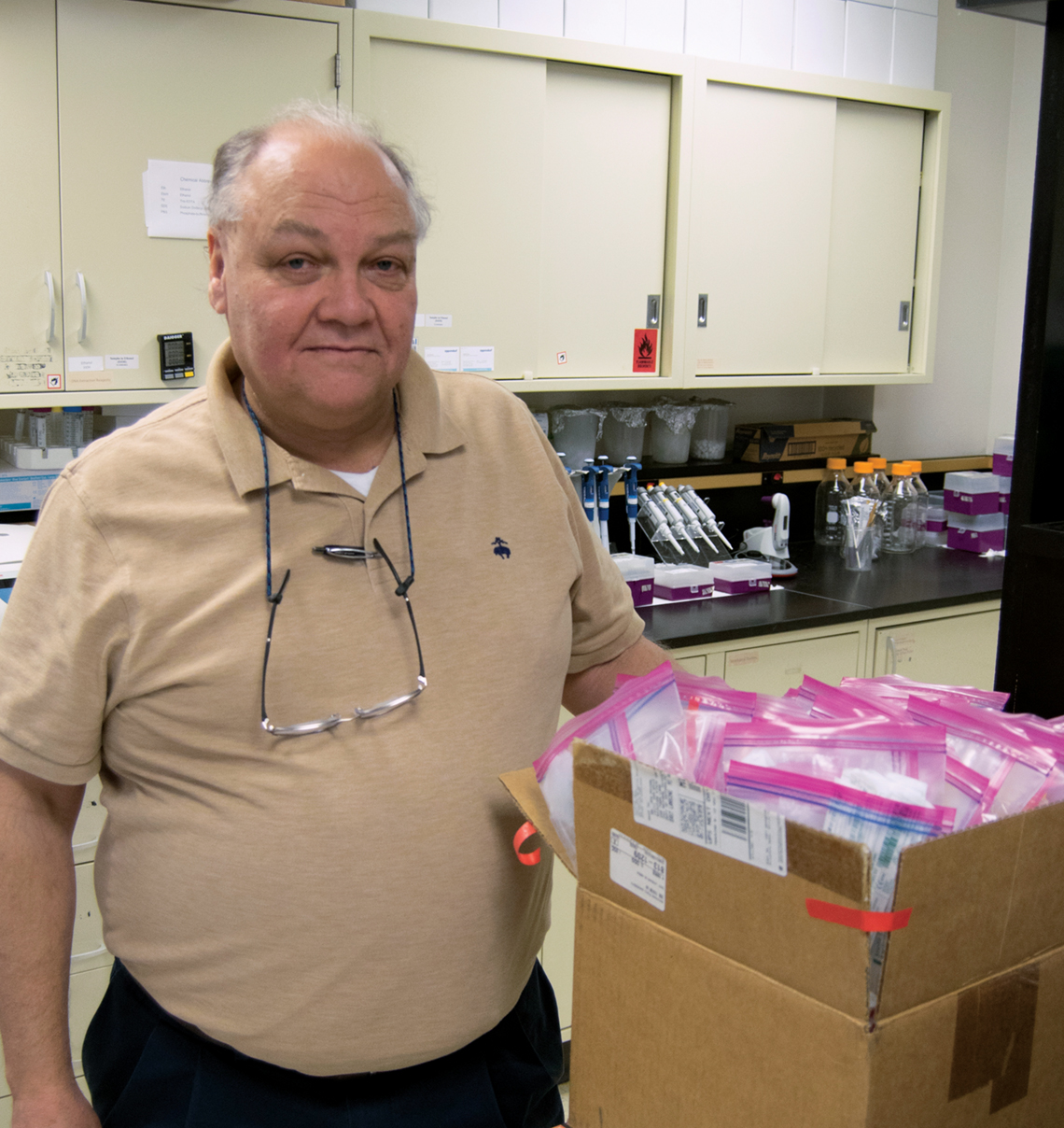 Carl Schmidt, Wayne County medical examiner, picks up microbiome kits from Benbow's lab.