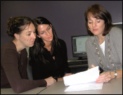 Staff attorney Delanie Pope (on right) reviews documents with students in the Chance at Childhood program.